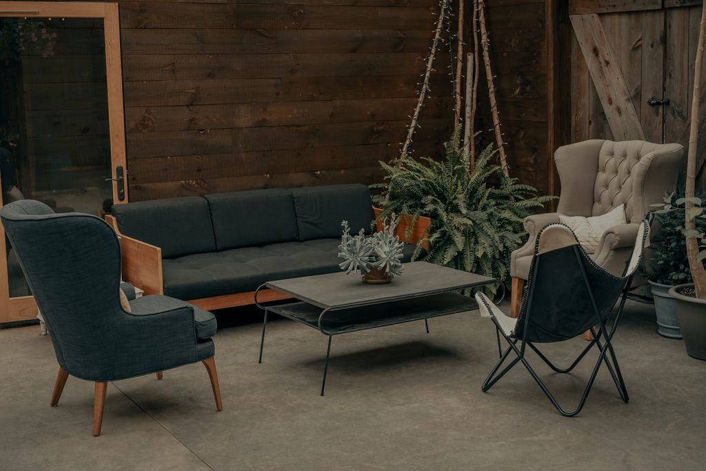 Outdoor terrace with stylish chairs and dark navy couch