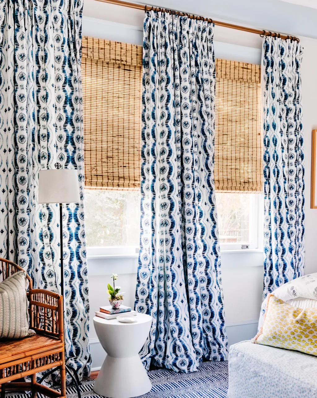 Living room with blue and white curtains pattern and bamboo blinds 
