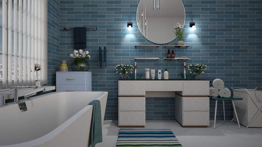 Bathroom with blue wall tiles, white tub and vanity