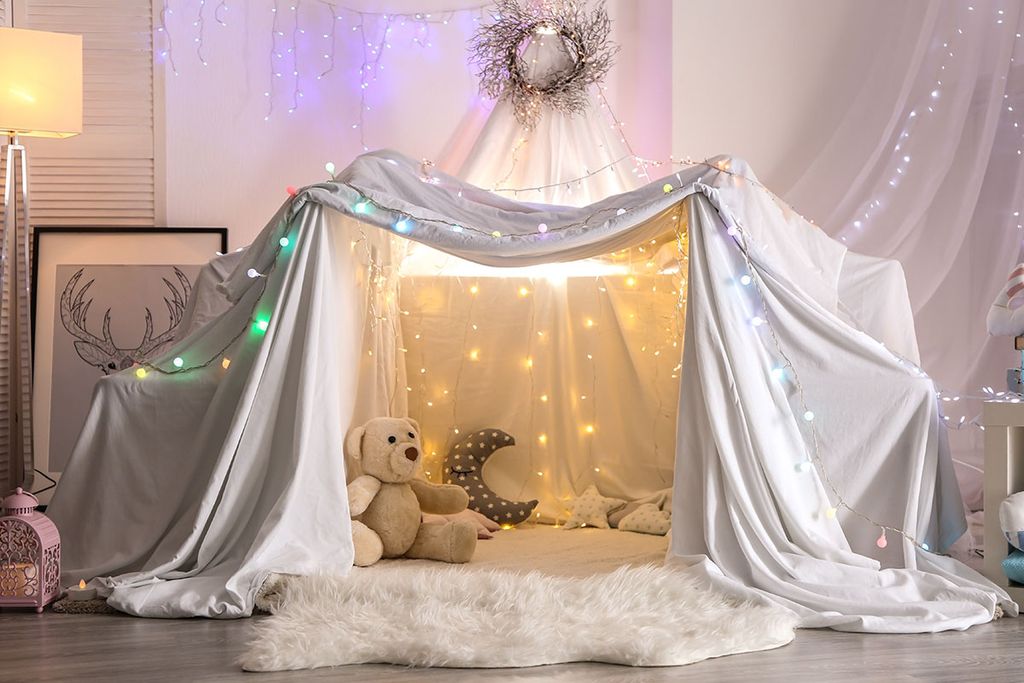 White pillow fort in child bedroom with teddy bear and moon pillow
