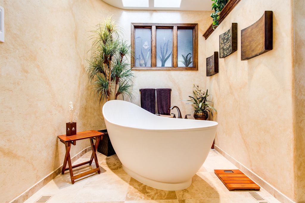 Freestanding tub with wood accents and soft orange coloured walls