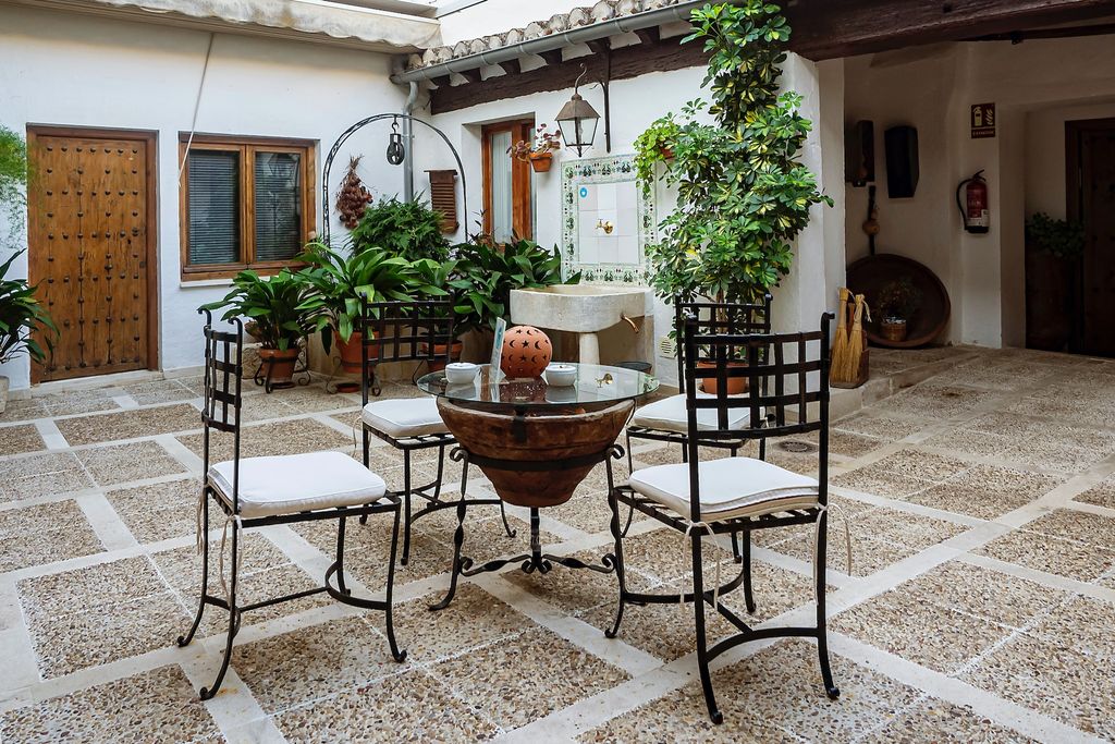 Terrace with iron furniture, plants and floor tiles