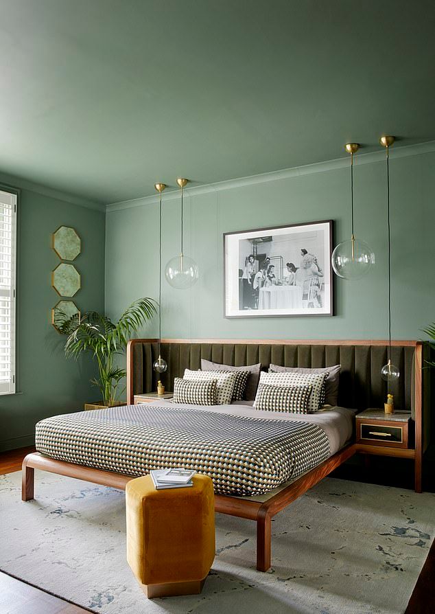 Bedroom with wooden bed, green wall color and gold velvet ottoman