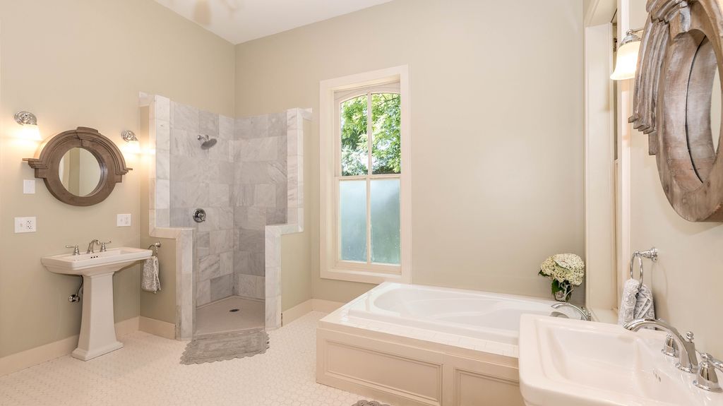 Bathroom with low bathtub and tiled shower stall