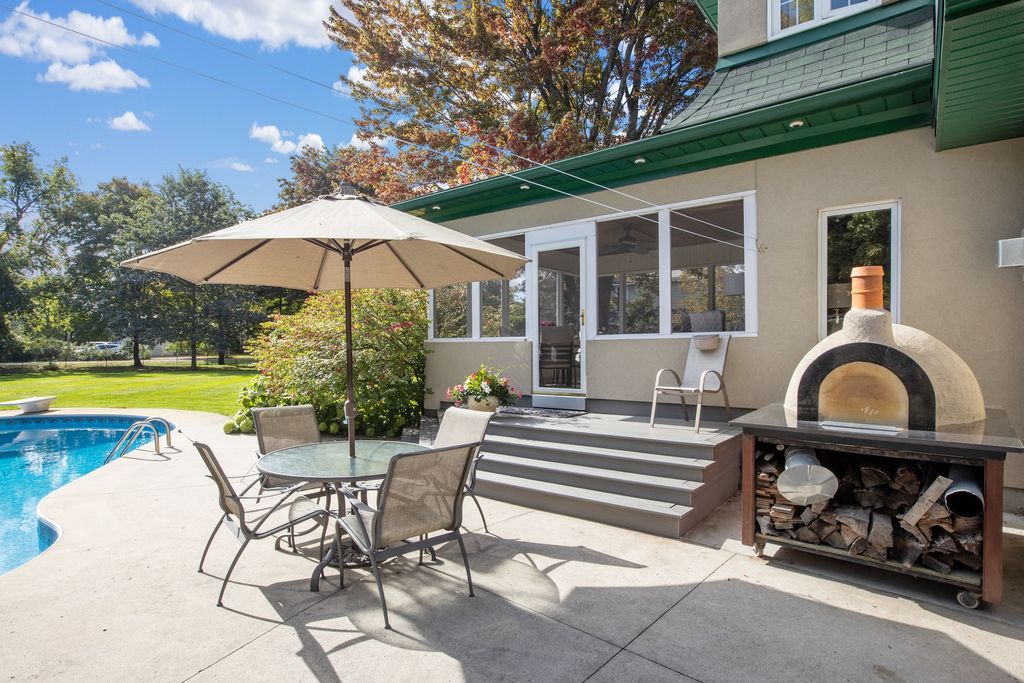 Patio with table, chairs, umbrella and wood fireplace