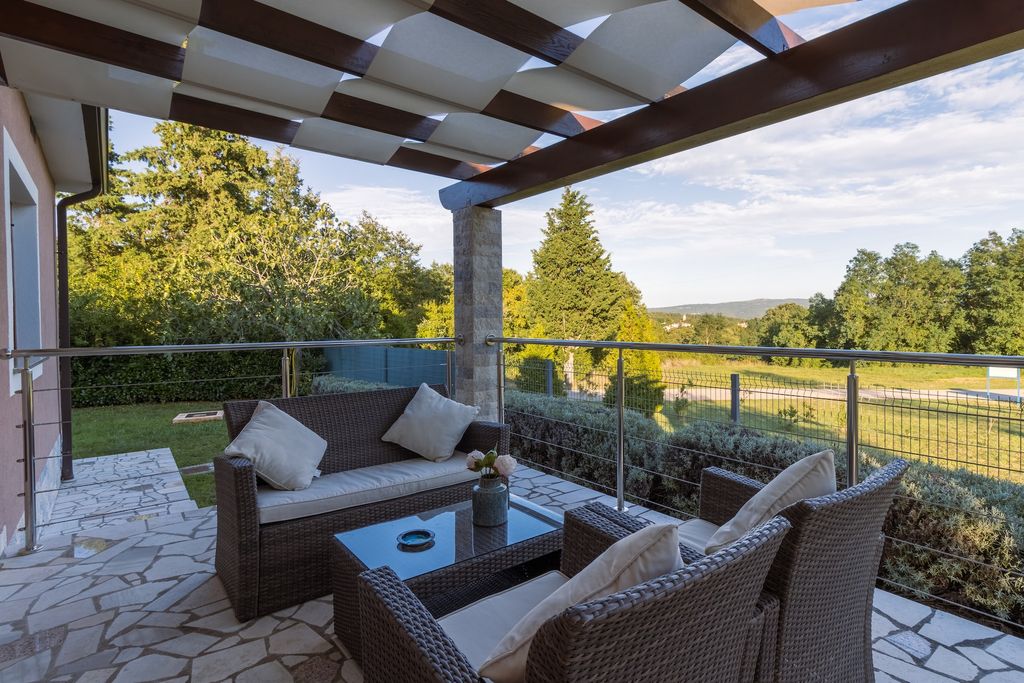 Outdoor terrace with patio furniture and overhead shelter 