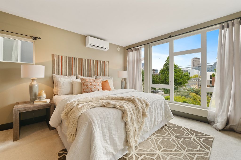 Bedroom with beige colours on walls and sheets and floor to ceiling windows