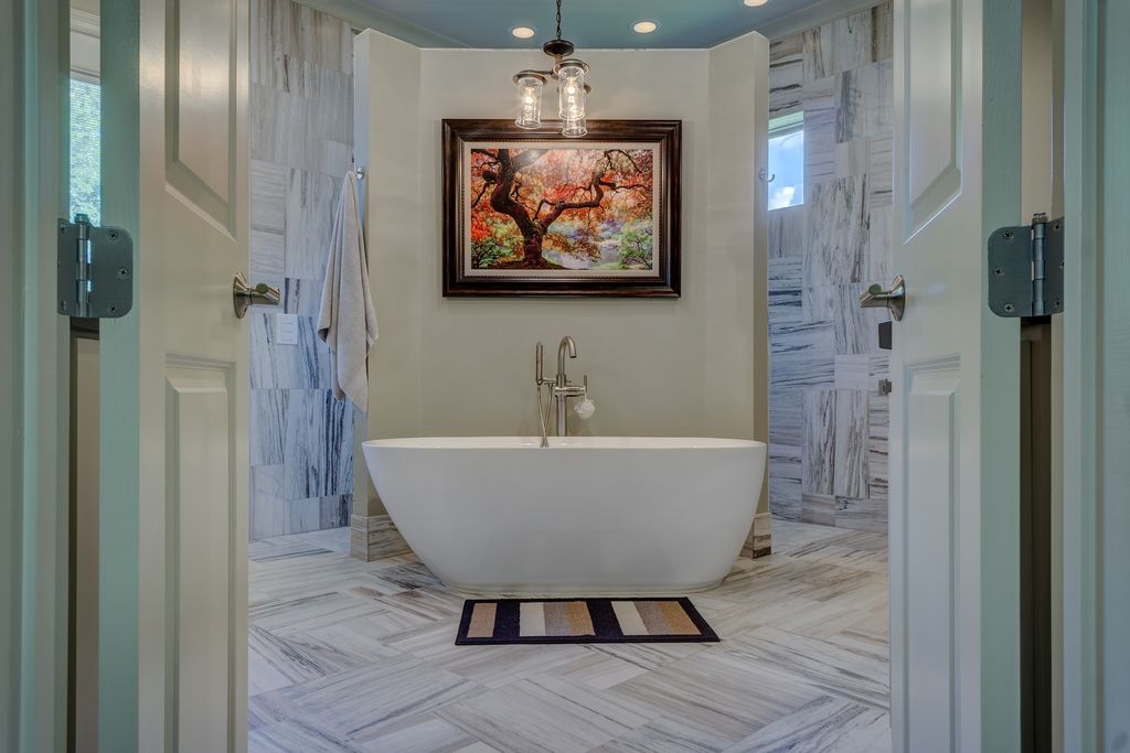Bathroom with freestanding bathtub and large painting