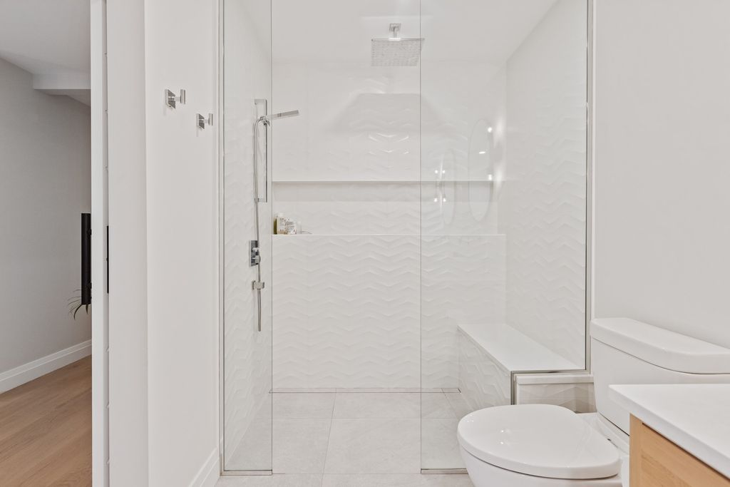 Glass shower with white tiles