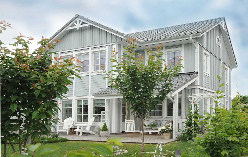 Elegant farmhouse with big windows and light grey exterior panelling 