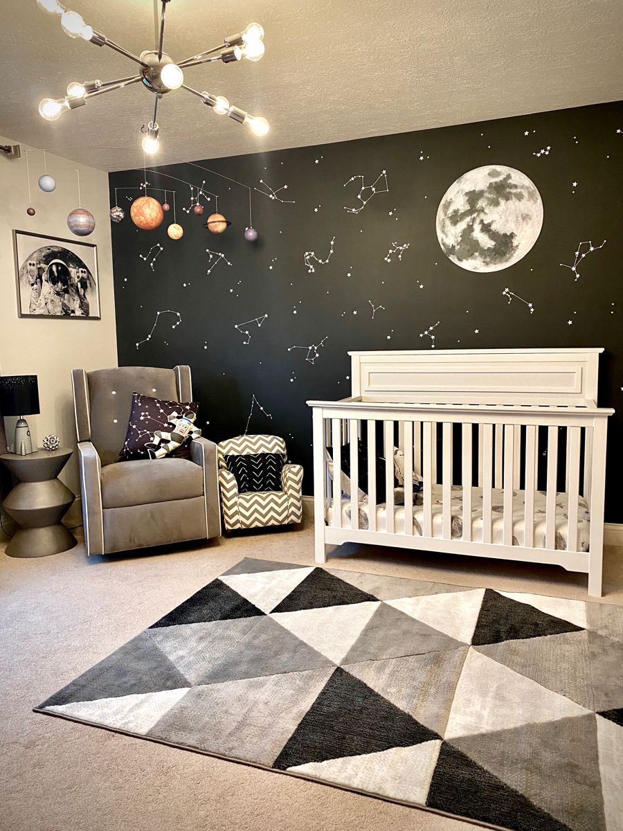 Space themed baby room with dark grey accent wall